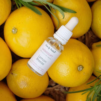 care by nature vaskeduft lemon breeze i klar glasflaske ovenpå citroner og rosmarin i flettet kurv