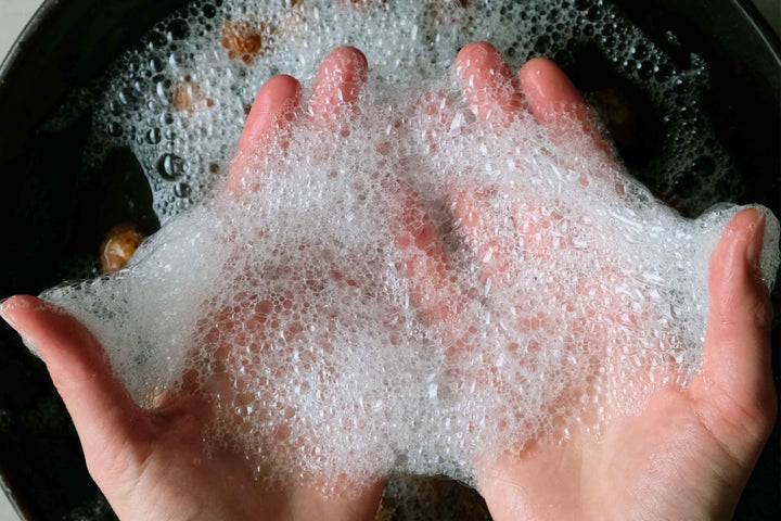 Sæbebær fra care by nature der ligger i vand og bliver skummet op med hænderne så der former sig naturlig sæbeskum fra sæbebærrene der indeholder naturlig sæbe kaldet saponiner